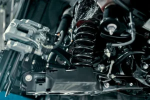 Close-up of vehicle's suspension system including spring and control arm behind brake assembly