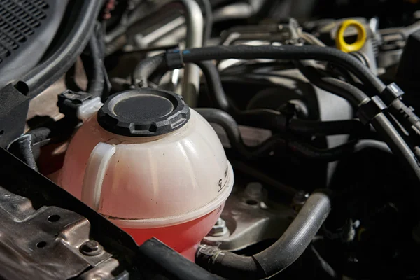 Red coolant liquid in clear plastic coolant expansion tank