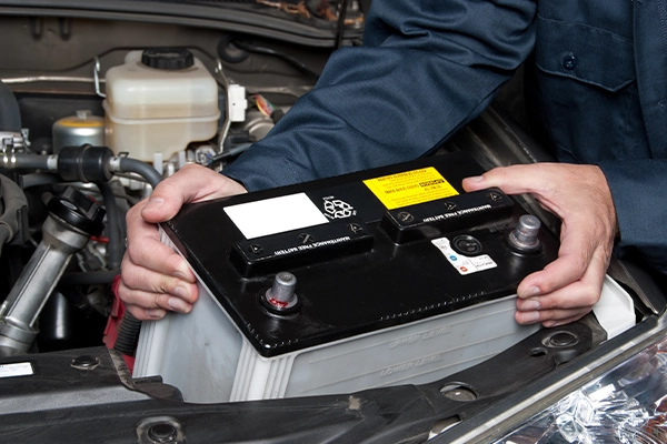 Technician removing car battery
