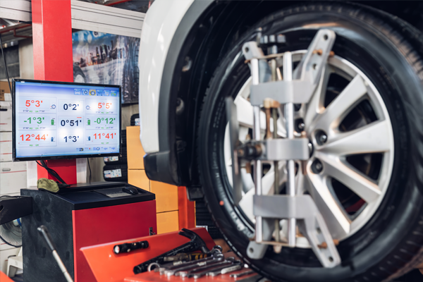 close-up look at a wheel alignment and data on the computer