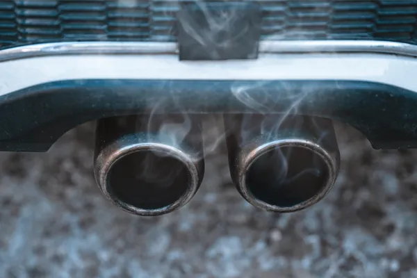 smoke coming from a vehicles exhaust pipe 